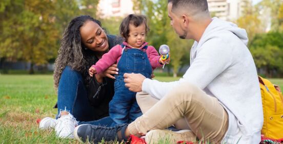 A family sitting together on the grass in a park