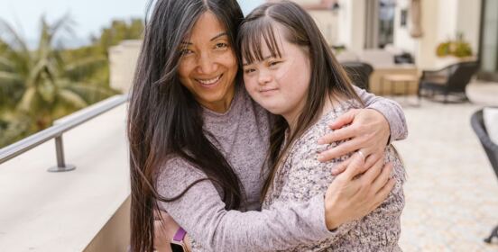 A respite worker  embracing a young woman outdoors